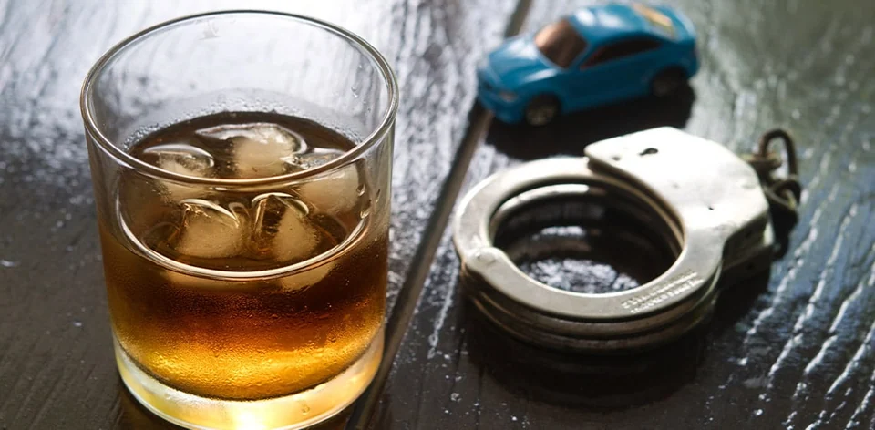 Still life of car keys, a glass and handcuffs
